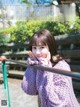 A woman in a purple sweater leaning against a railing.