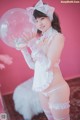 A woman in a white and pink outfit holding a bubble.